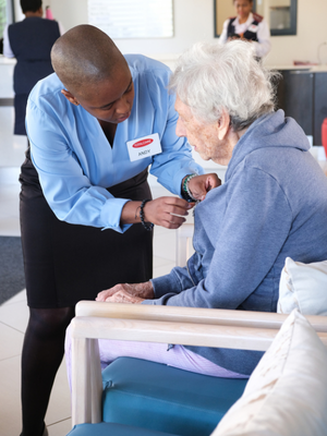 A care team member supporting an older adult at a table