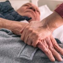 Hands of person with dementia and care nurse